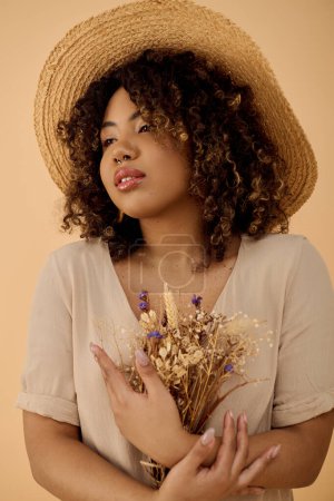 A graceful African American woman, with curly hair, wearing a straw hat, holding a vibrant bouquet of flowers.
