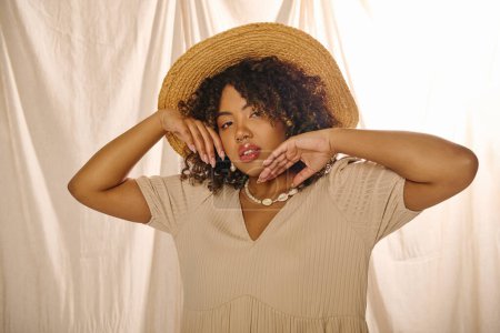 Téléchargez les photos : A beautiful young African American woman with curly hair wearing a straw hat and summer dress poses gracefully for a picture. - en image libre de droit