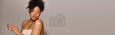 Téléchargez les photos : A stunning African American woman in a white dress delicately posing, exuding elegance and grace. - en image libre de droit