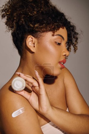 Foto de Una hermosa joven afroamericana con el pelo rizado cubierto de una gruesa capa de crema, haciendo hincapié en la belleza y el cuidado de la piel. - Imagen libre de derechos
