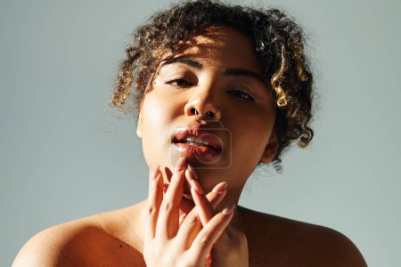 Foto de Mujer afroamericana con la mano cubriendo la boca en pensamiento profundo. - Imagen libre de derechos