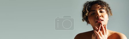Téléchargez les photos : Une belle femme afro-américaine avec les mains dans la bouche sur un fond vibrant. - en image libre de droit