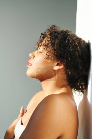 Foto de Primer plano de una mujer afroamericana con un delicado sujetador sobre un vibrante telón de fondo. - Imagen libre de derechos
