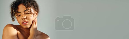 Photo for African American woman with hand on face in thoughtful pose on vibrant backdrop. - Royalty Free Image