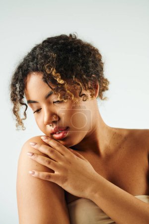 Afroamerikanerin hält vor vibrierender Kulisse anmutig die Hände vor der Brust.