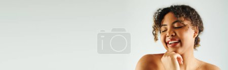 Photo for A beautiful African American woman laughing with hands clasped together. - Royalty Free Image