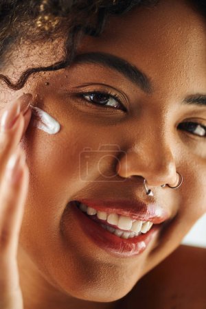 Foto de Mujer afroamericana aplicándose crema en la cara - Imagen libre de derechos