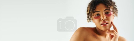 Photo for Young African American woman showcasing eye patches on a vibrant backdrop. - Royalty Free Image