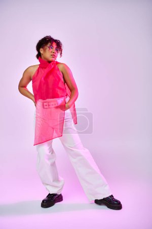 Téléchargez les photos : Une femme afro-américaine pose avec confiance dans une chemise rose et un pantalon blanc sur un fond vibrant. - en image libre de droit
