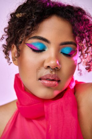 Beautiful African American woman poses with bright blue eye shadows.