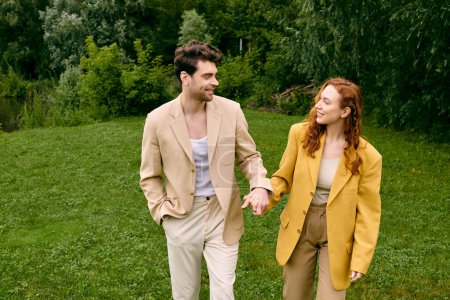 Ein Mann und eine Frau halten sich Händchen, während sie bei einem romantischen Date auf einer grünen Wiese spazieren gehen, umgeben von der Schönheit der Natur.