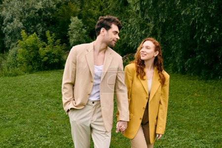 Ein Paar, das ein romantisches Date genießt, geht Hand in Hand durch ein sattes grünes Feld, umgeben von Naturschönheiten.