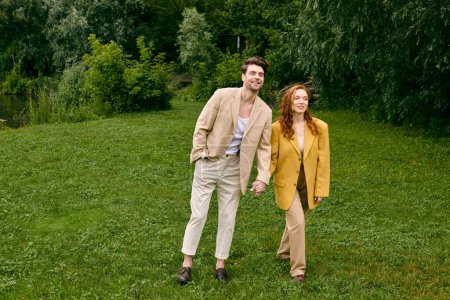 A man and a woman holding hands in a lush green field on a romantic date, forming a deep connection amidst natures beauty.