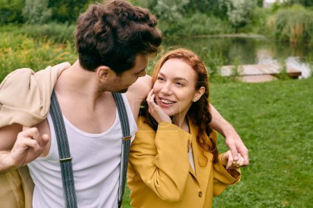 Foto de Un hombre y una mujer se paran lado a lado en un parque verde, disfrutando de una cita romántica en medio de un entorno natural sereno. - Imagen libre de derechos