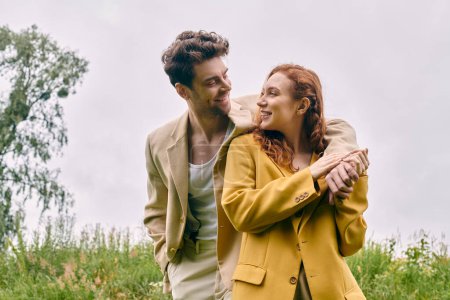 Ein Mann und eine Frau stehen zusammen in einem üppigen Feld und genießen ein heiteres romantisches Date im Herzen der Schönheit der Natur.