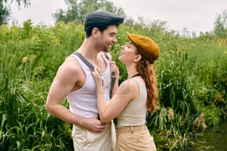 Ein Mann und eine Frau, ein schönes Paar, stehen zusammen in einem üppig grünen Park und genießen ein romantisches Date in einer natürlichen Umgebung.