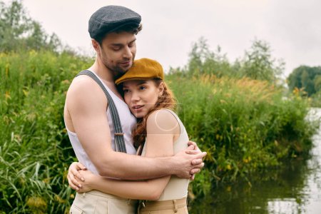 Un hombre y una mujer comparten un tierno abrazo frente a un tranquilo cuerpo de agua en un entorno de parque verde.
