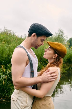 Téléchargez les photos : Un homme et une femme se tiennent près d'un parc verdoyant, partageant un moment romantique sous les arbres. - en image libre de droit