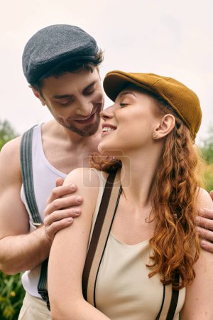Un hombre y una mujer de pie cerca, abrazados en un momento romántico en un entorno verde parque.