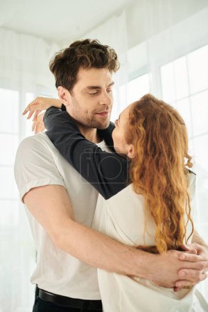 Un hombre y una mujer abrazan fuertemente, sus cuerpos entrelazados en un momento amoroso e íntimo.