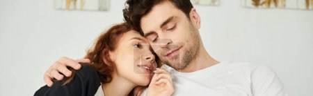 Un homme et une femme se tiennent à proximité, partageant un moment d'intimité et de connexion dans un cadre de chambre à coucher.