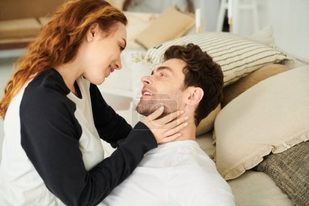 Un homme et une femme se reposent paisiblement sur un lit, enveloppés les uns dans les autres bras, profitant de moments intimes ensemble.