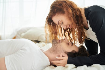 Foto de Un hombre y una mujer están tranquilamente tendidos uno al lado del otro en una cama, disfrutando de la compañía de los demás con un sentido de amor y tranquilidad.. - Imagen libre de derechos