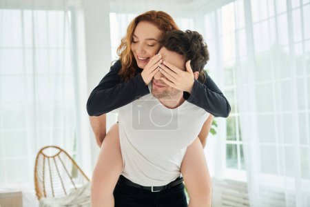 Téléchargez les photos : Un homme tient tendrement une femme dans ses bras, exprimant amour et affection dans un cadre de chambre confortable. - en image libre de droit