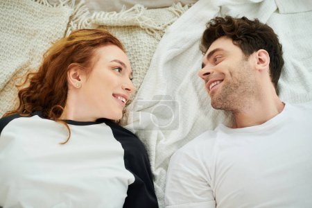 Téléchargez les photos : Un homme et une femme couchés ensemble dans leur lit, profitant d'un moment paisible de convivialité. - en image libre de droit