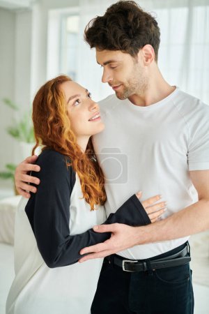 A man and woman, entwined in a warm embrace, express their love and connection in a tender moment.