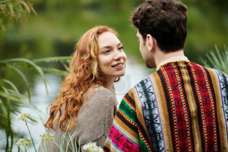 Téléchargez les photos : Un homme et une femme élégants en tenue bohème se tiennent étroitement ensemble dans un parc verdoyant, exsudant l'amour et la connexion. - en image libre de droit