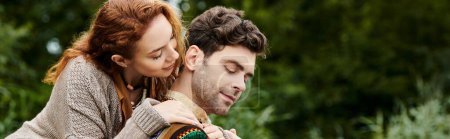 Ein Mann trägt eine Frau zärtlich auf dem Rücken bei einem romantischen Boho-Date in einem üppig grünen Park.