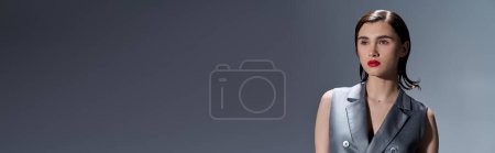 Photo for Stylish woman exudes glamour in a shimmering silver vest, her bold red lip adding a touch of sophistication. - Royalty Free Image