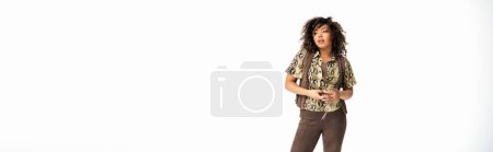 Foto de Mujer afroamericana elegante con el pelo rizado posando sobre fondo blanco y mirando hacia otro lado, pancarta - Imagen libre de derechos
