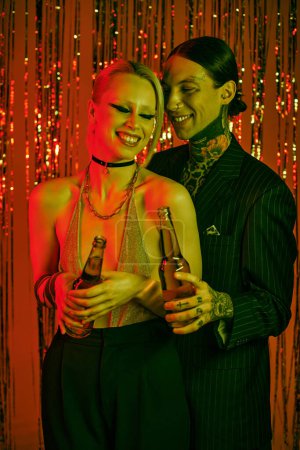 Téléchargez les photos : Un homme et une femme debout côte à côte lors d'une fête de rave animée - en image libre de droit