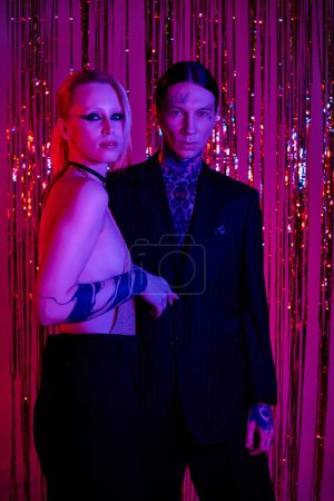 Téléchargez les photos : Un couple se tient côte à côte lors d'une rave party ou d'une boîte de nuit animée - en image libre de droit