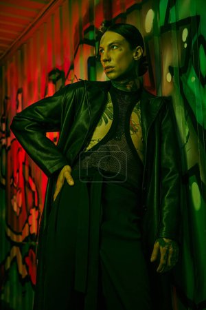 Photo for A woman stands in front of a vibrant wall covered in graffiti - Royalty Free Image
