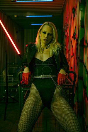 A woman sitting in a chair, holding a light saber in her hand