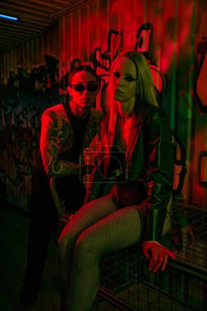 Photo for A man and a woman sitting closely next to each other at a lively rave party - Royalty Free Image