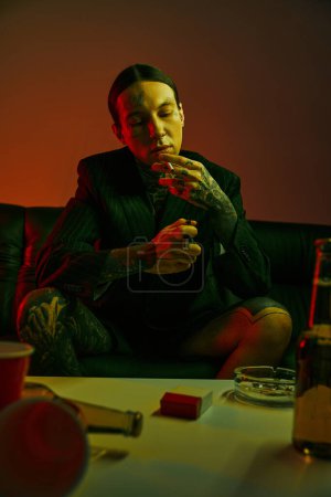 Photo for A man sitting on a couch, eating food - Royalty Free Image
