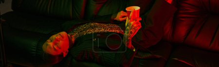 Photo for A person laying on a couch holding a lit candle - Royalty Free Image