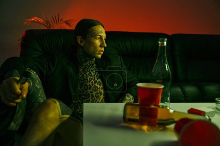 Photo for A man is seated at a table with a bottle of wine - Royalty Free Image