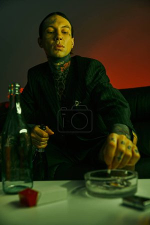 Foto de Un hombre sentado en una mesa con una botella de vino - Imagen libre de derechos