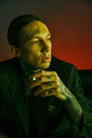 A man with facial tattoos wearing a suit at a crowded rave club