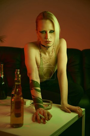 Una mujer con tatuajes apoyada en una mesa