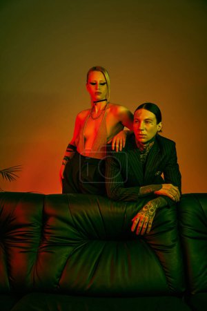 Photo for A man and a woman seated on a couch indoors - Royalty Free Image