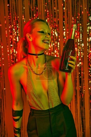 Una mujer sosteniendo una botella en su mano en una animada fiesta o discoteca