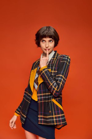 Photo for Student with short hair posing in stylish checkered blazer on orange background, college uniform - Royalty Free Image