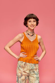 positive young woman in her 20s with short hair in vibrant tank top posing on pink background Poster #712424828