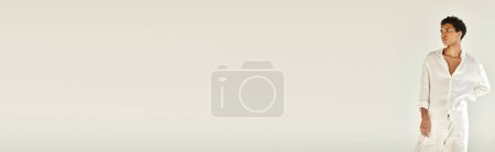 Téléchargez les photos : Élégant homme afro-américain dans des vêtements en lin chic regardant loin sur fond beige, bannière - en image libre de droit